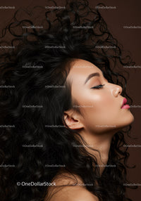 Serene woman with flowing curly hair against brown background