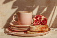 Pink Ceramic Mug with Plates and Fresh Pomegranate Slices