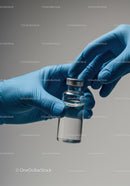 Close-Up of Gloved Hands Holding a Glass Vial in Medical Laboratory