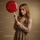 Thoughtful girl holding oversized red lollipop prop