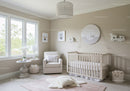 Nursery with White Baby Crib, Armchair, Wall Art and Natural Light