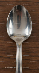 Close up of stainless steel spoon on wooden surface