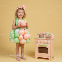 Toddler girl with balloon dress holding tea cup