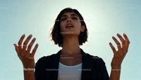 Young woman expressing emotion outdoors with open hands