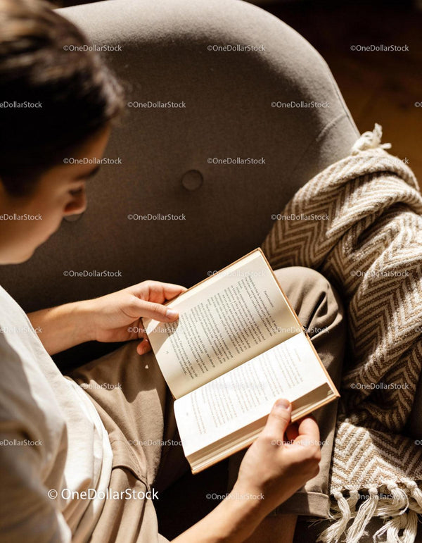 Relaxed person reading book in cozy armchair