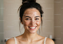 Young Woman with Acne Scars Smiling in Casual Indoor Setting