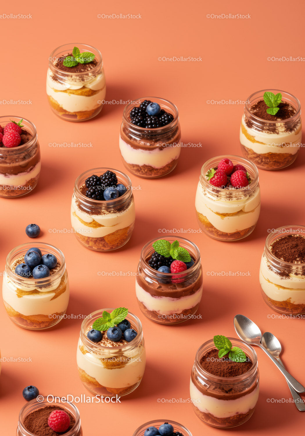 Assorted creamy desserts with fresh berries in glass jars