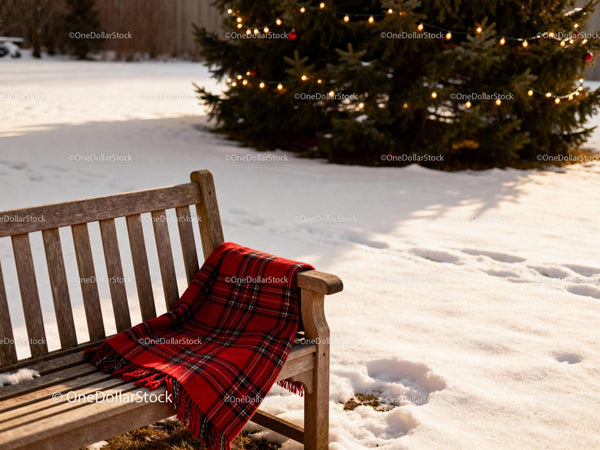 Wooden bench with cozy red plaid blanket outdoors