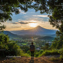 Majestic Mountain Sunset with Lush Green Forest and Hiker