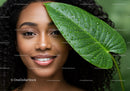Young Woman with Curly Hair and Tropical Leaf in Natural Setting
