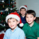 Three Boys Celebrating Christmas by Decorated Tree