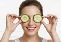Smiling Woman with Fresh Cucumber Slices Over Eyes