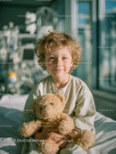 Cheerful Child Sitting on Hospital Bed Holding Teddy Bear