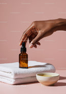 Elegant Hand with Amber Dropper Bottle and Towel for Skincare