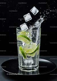 Refreshing sparkling water with lime and ice cubes splash
