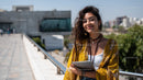 Stylish Woman Smiling while Using Tablet in Urban Outdoors