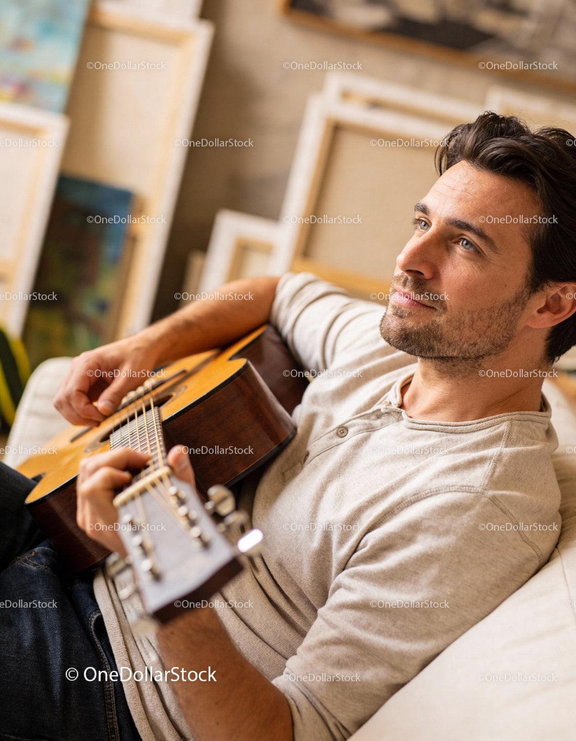 Young man playing guitar relaxed at home
