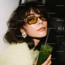 Fashionable Woman with Yellow Sunglasses Holding Green Drink in Casual Outfit