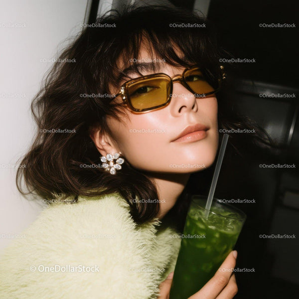 Fashionable Woman with Yellow Sunglasses Holding Green Drink in Casual Outfit