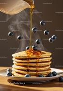 Stack of fluffy pancakes with syrup and fresh blueberries