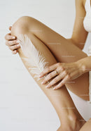 Elegant Woman's Legs with White Feather and Gold Ring