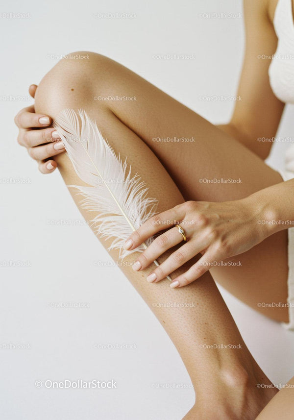 Elegant Woman's Legs with White Feather and Gold Ring