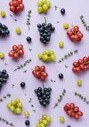Fresh colorful grape clusters arranged on pastel surface