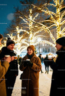 Friends enjoying warm drinks at winter holiday market