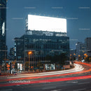 Night Traffic Flow by Illuminated City Billboard