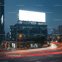 Night Traffic Flow by Illuminated City Billboard