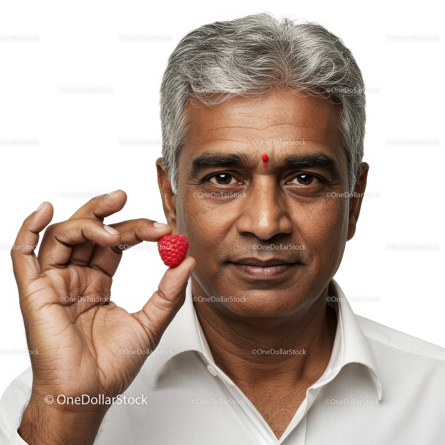 Mature Man Holding Raspberry with Calm Expression in Studio