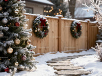 Snowy Christmas Tree and Wreaths Along Wooden Fence