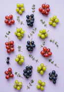 Colorful fresh grape clusters arranged on pale surface