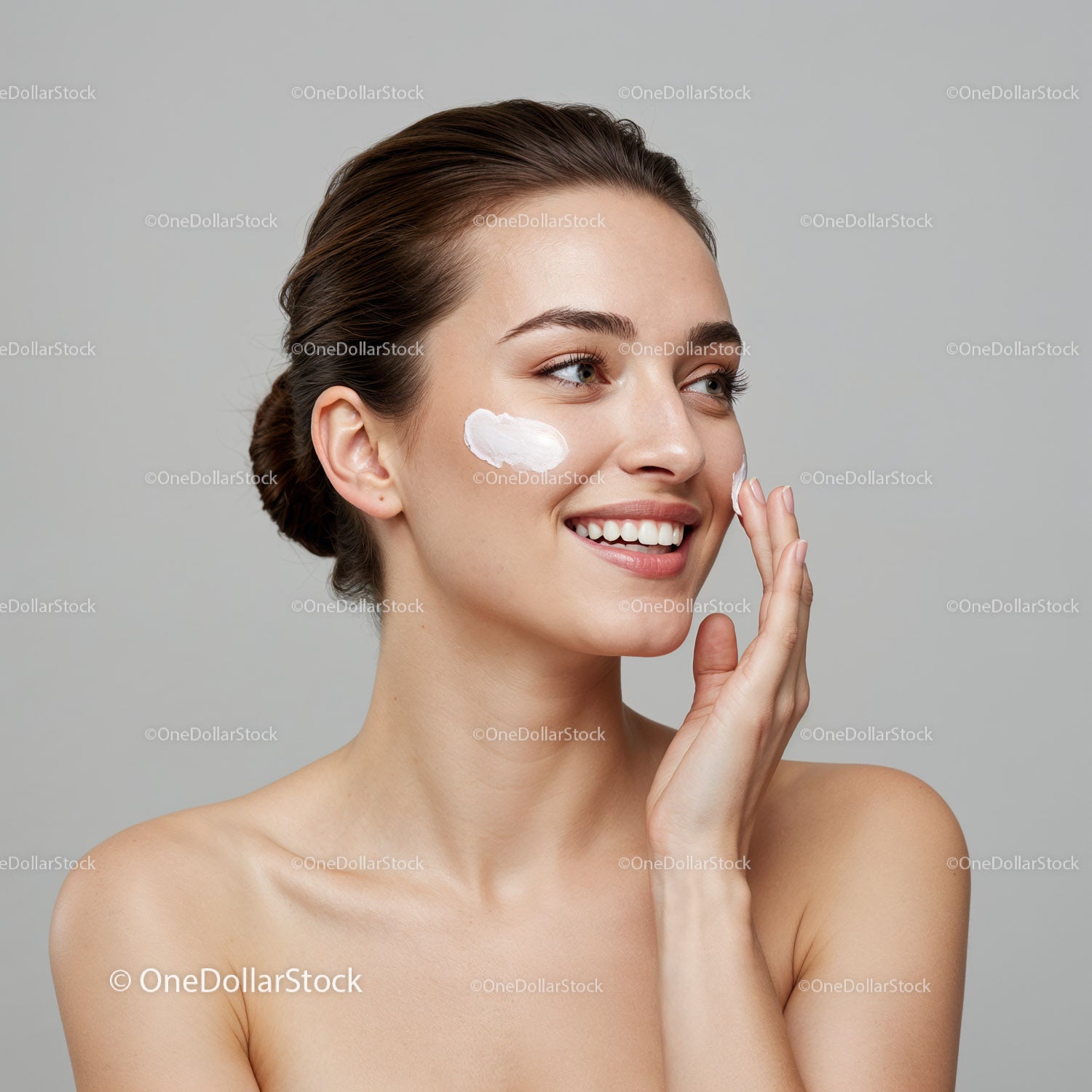 Young Woman Applying Facial Moisturizer With Skincare Products