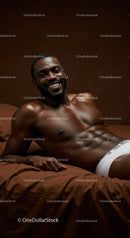 Smiling muscular man relaxing on brown bed in white underwear