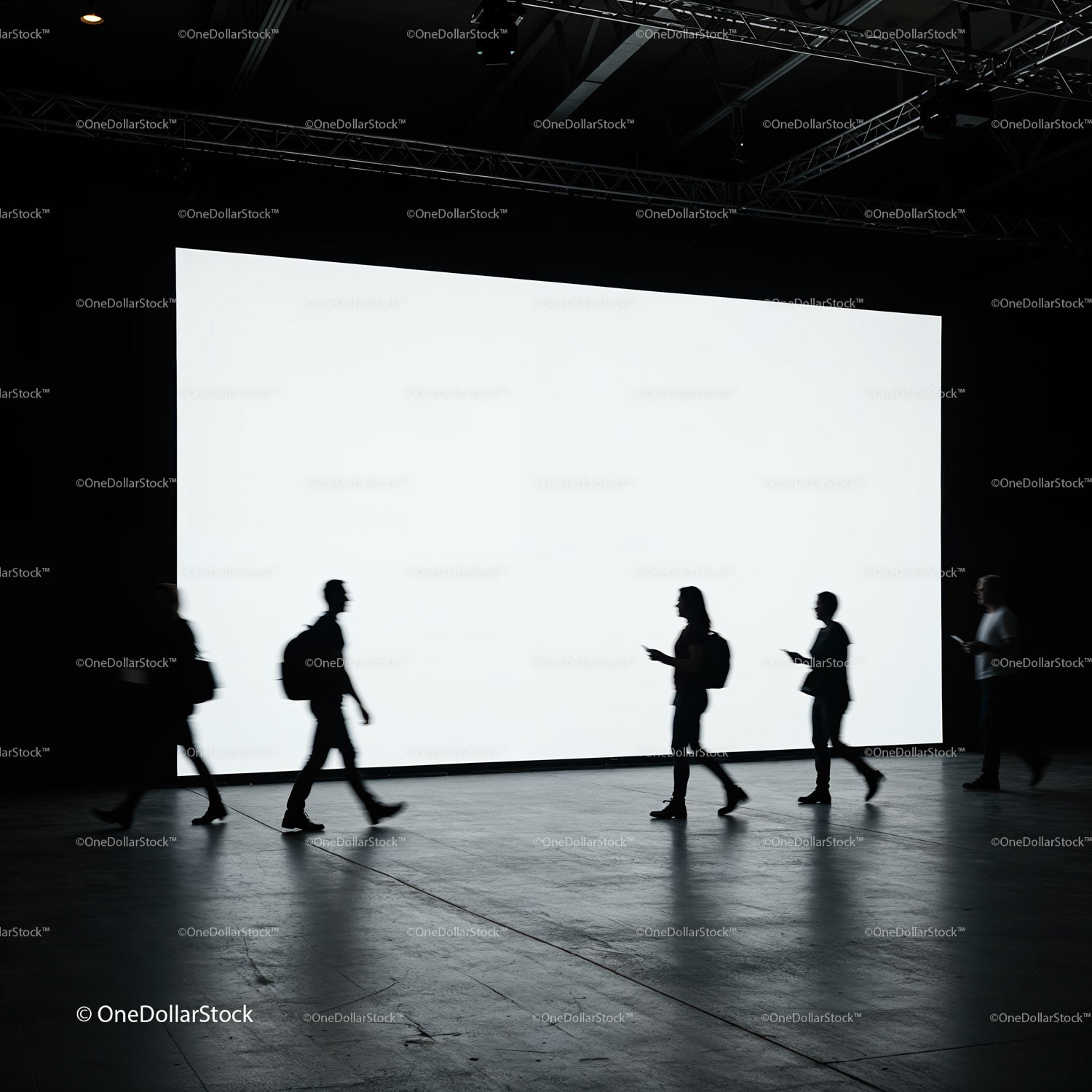 Silhouetted People Walking Past Large Bright Screen