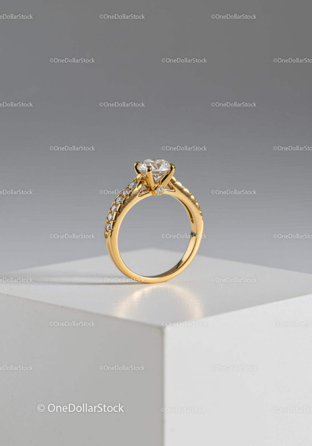 Elegant Gold Engagement Ring with Diamond Solitaire on a White Display