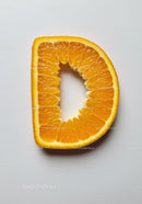 Fresh orange slice shaped like letter D on white background