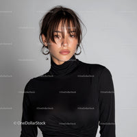 Stylish Young Woman in Black Turtleneck with Layered Hair and Hoop Earrings