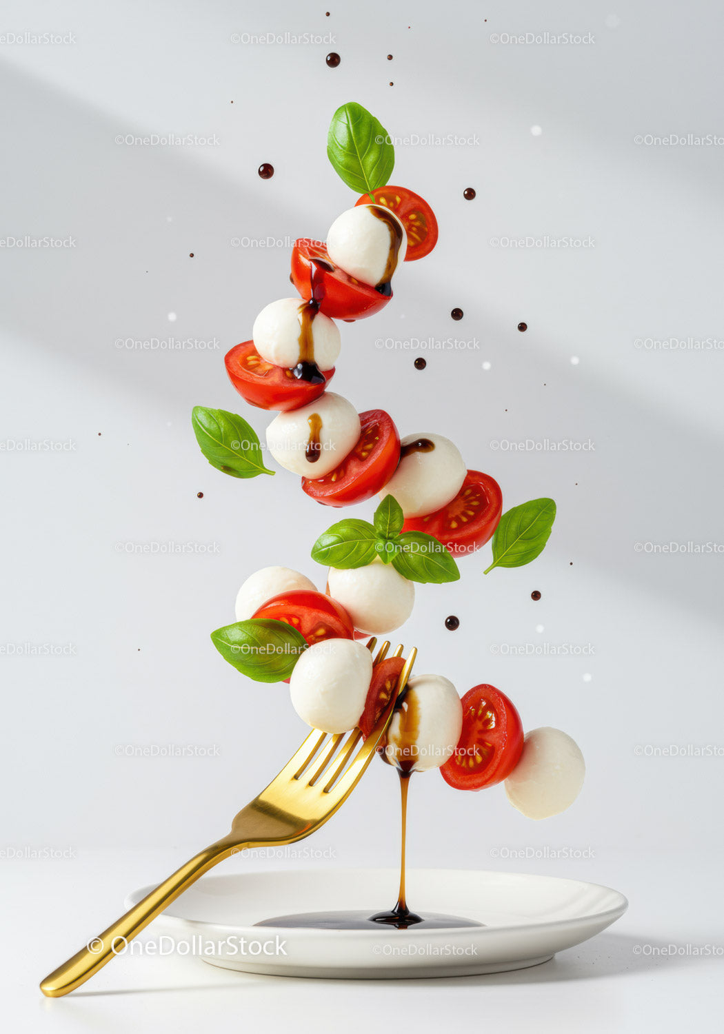 Latająca sałatka Caprese z sosem balsamicznym i złotym widelcem