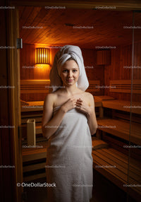 Young Woman Relaxing in Sauna with Towel and Towel Wrapped Hair