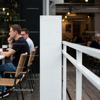 Quiet coffee shop patio with thoughtful patrons outdoors