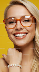 Smiling blonde woman wearing orange glasses and pearl bracelet