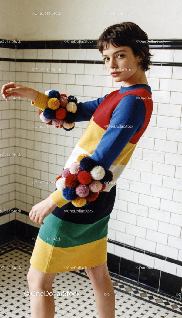 Young woman in colorful sweater with pom-pom details