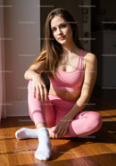 Young woman relaxing at home in pink activewear