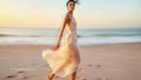 Graceful Woman Walking Along a Serene Beach at Dusk