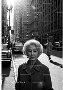 Elderly Woman in Busy City Street Surrounded by Vintage Cars