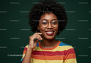 Bright Smiling Woman with Curly Hair and Glasses in Colorful Striped Shirt