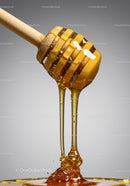 Golden honey flowing smoothly from wooden dipper