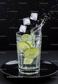 Refreshing sparkling water with lime and ice cubes splash